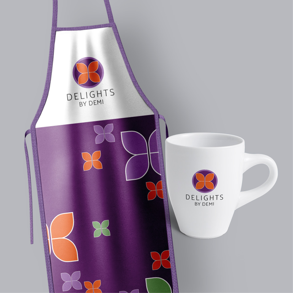 A purple apron and mug with the branding designs for Delights by Demi on it.